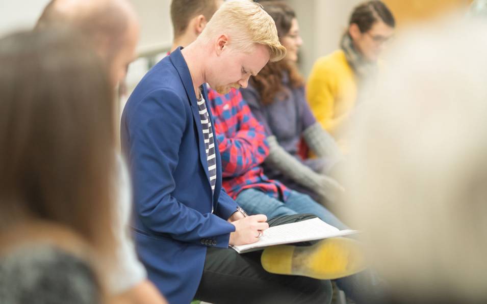 Author James McDermott writing on a notepad.